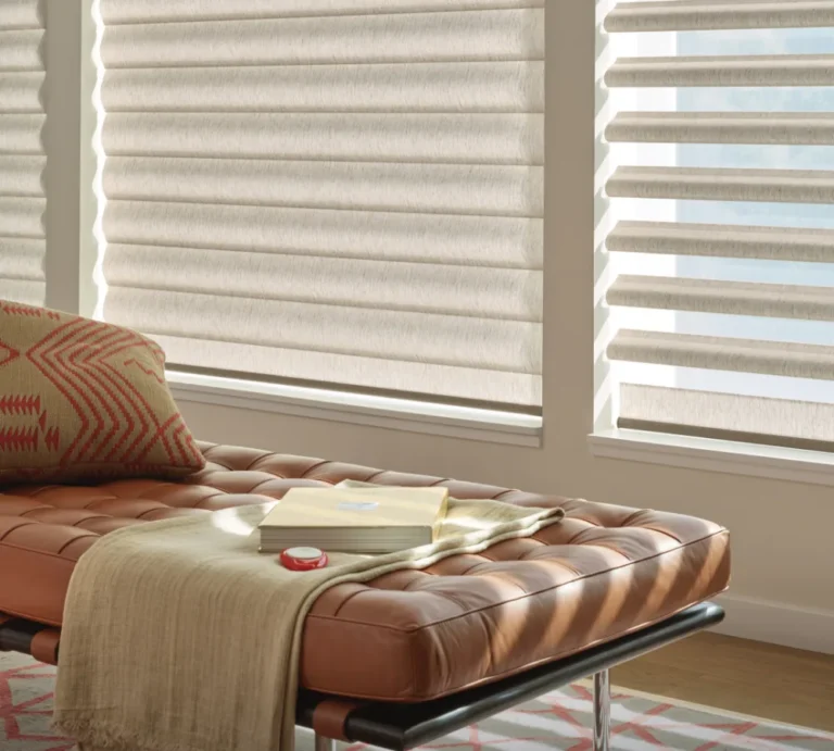 Hunter Douglas Pirouette Window Shadings with open fabric vanes above a leather chaise